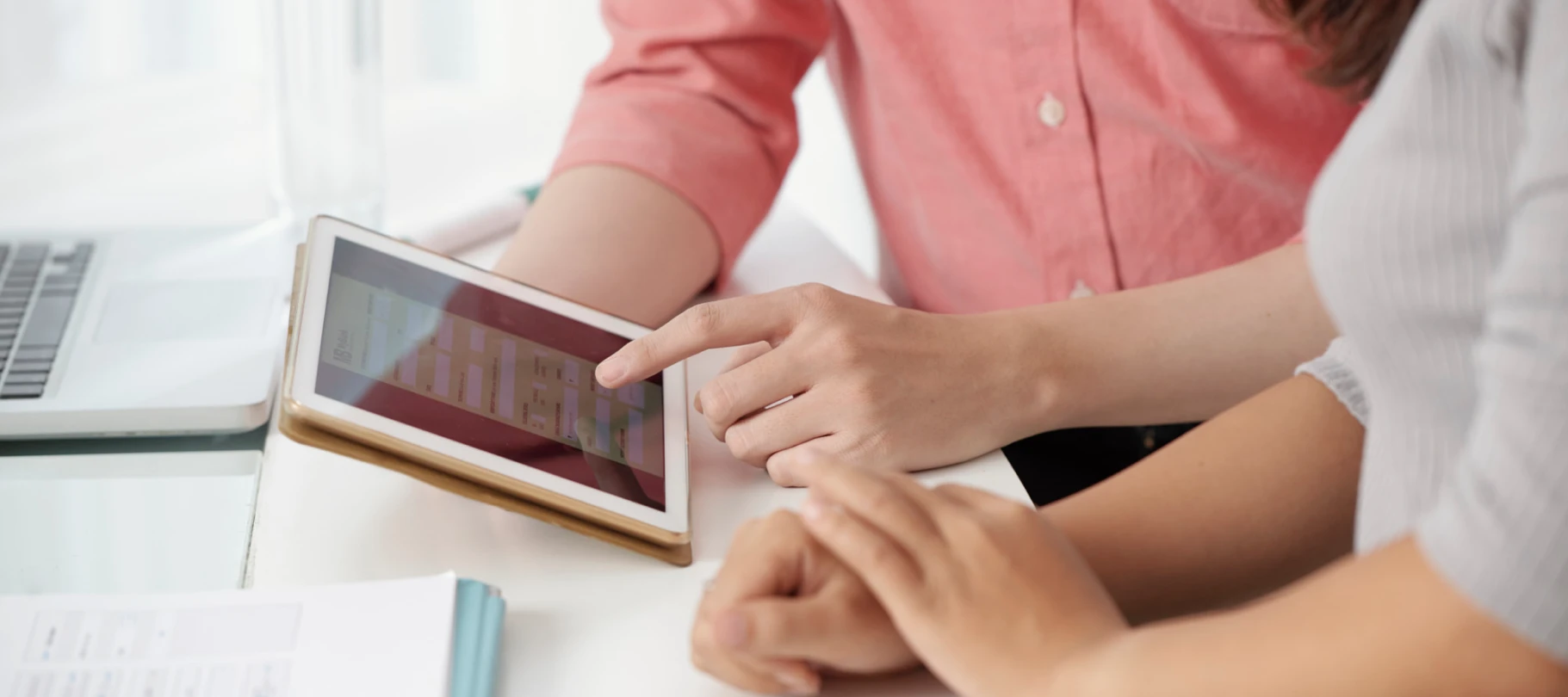 Primer plano de manos utilizando una tablet para completar un formulario digital de negocios.